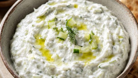 Caciki (tzatziki) sos u keramičkoj činiji, poslužen sa grčkim pita hlebom i maslinama.