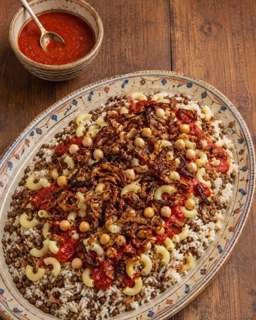 Koshari recept sa pirinčem, smeđim sočivom, testeninom, leblebijama, paradajz-sosom i prženim lukom.